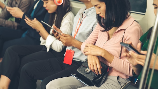 Young people using mobile phone in public underground train