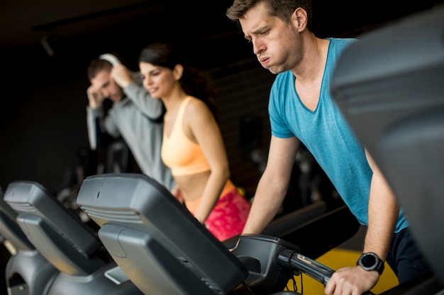 Young people using threadmill in modern gym