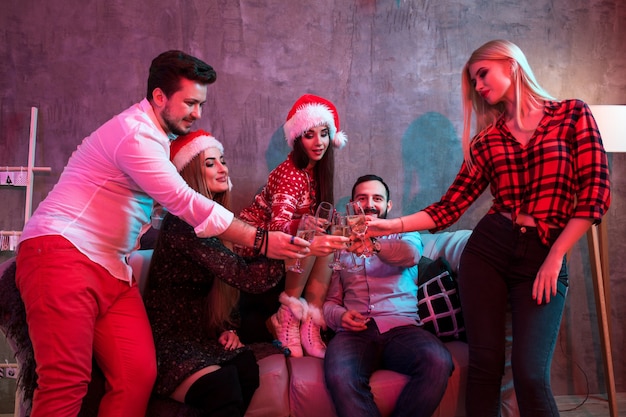 Young people with glasses of champagne at Christmas party