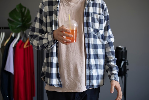 A young person holding fresh cold summer cocktail with a straw