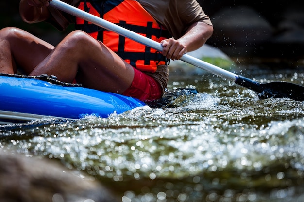 Young person is rafting in river.