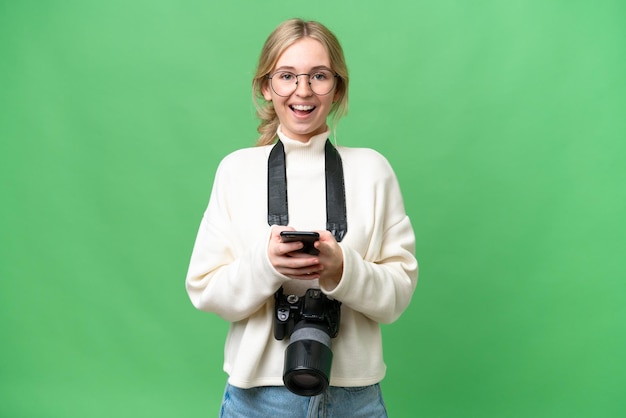 Young photographer English woman over isolated background surprised and sending a message