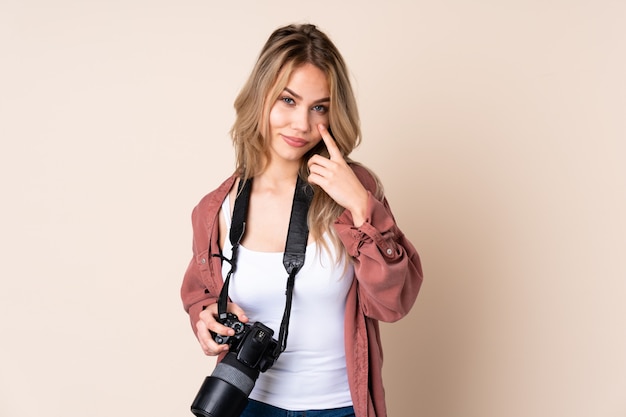 Young photographer girl over isolated showing something