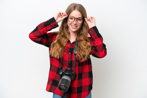 Young photographer pretty woman isolated on white background with glasses and surprised