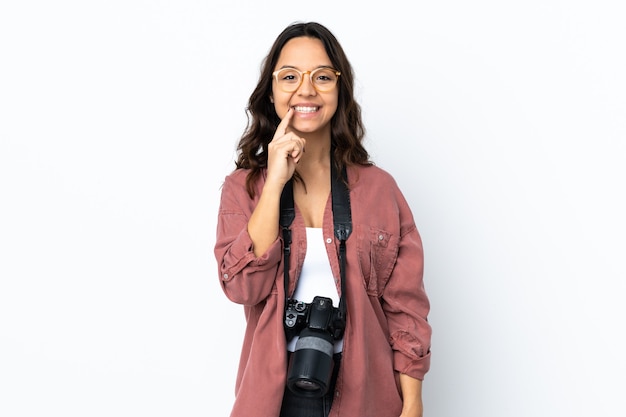 Young photographer woman over isolated white background showing a sign of silence gesture putting finger in mouth