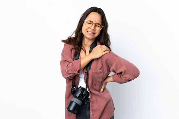 Young photographer woman over isolated white wall suffering from pain in shoulder for having made an effort