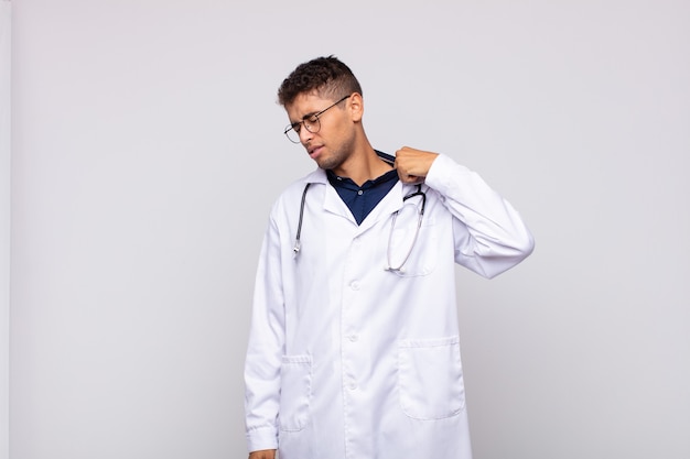 young physician man feeling stressed, anxious, tired and frustrated, pulling shirt neck, looking frustrated with problem