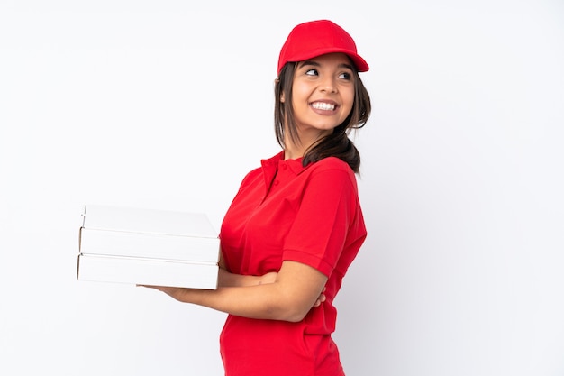 Young Pizza delivery woman over isolated white wall with arms crossed and happy