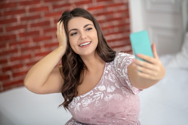 Young plus-size woman making selfie and looking happy