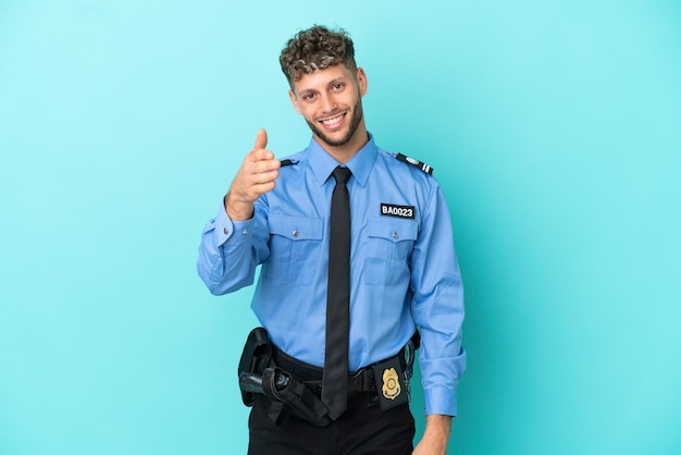 Young police blonde man isolated white on blue background shaking hands for closing a good deal