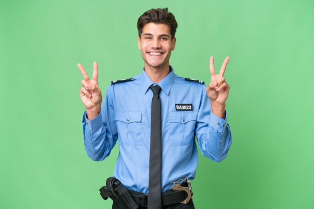 Young police man over isolated background showing victory sign with both hands