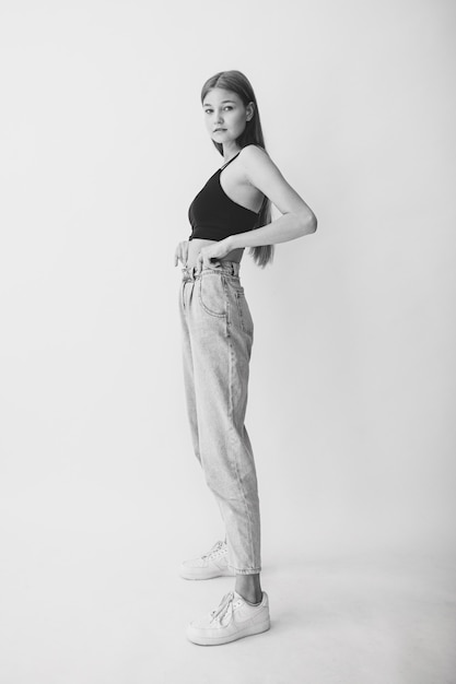 Young positive girl on a white background. Black and White.