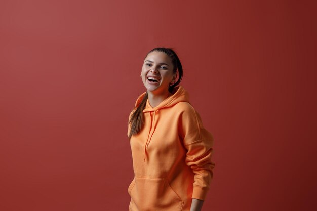 Young positive smiling woman in orange fitness sport outfit cloth dancing