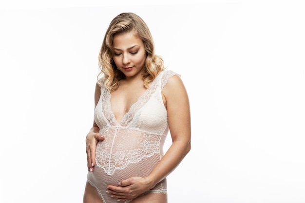 Young pregnant blonde woman in delicate underwear. Waiting for the baby.