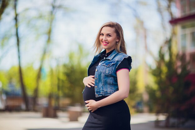 Young Pregnant Woman on Background Residential Building