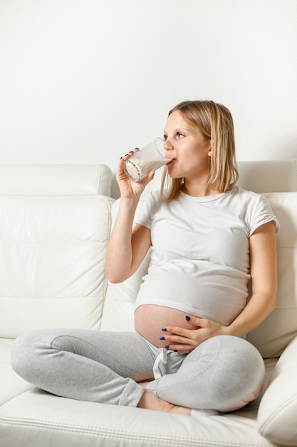 Young pregnant woman drinking milk