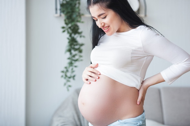 Young pregnant woman having a backache. Expecting woman feeling bad. Pregnant woman suffering from pain.