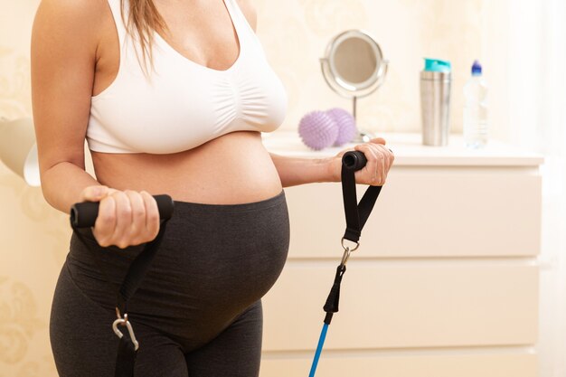 Young pregnant woman during her fitness workout at home