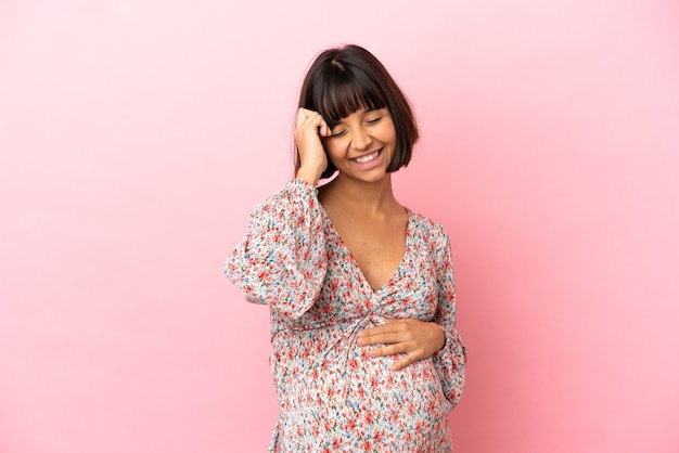 Young pregnant woman over isolated pink background smiling a lot