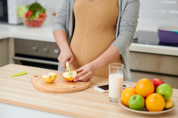 Young pregnant woman in the kitchen at home healthy snack