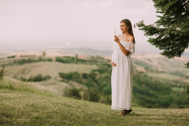 Young pregnant woman relaxing outside in nature