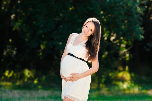 Young pregnant woman relaxing in the park