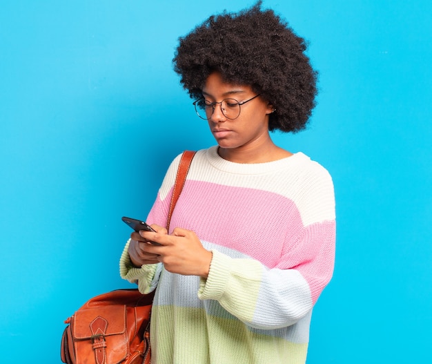 Young pretty afro student woman with a smart phone