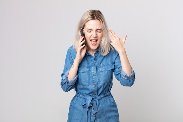 Young pretty albino woman looking unhappy and stressed, suicide gesture making gun sign and talking with a smartphone