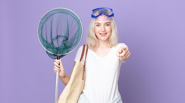 Young pretty albino woman pointing at camera choosing you with goggles and a fishing net