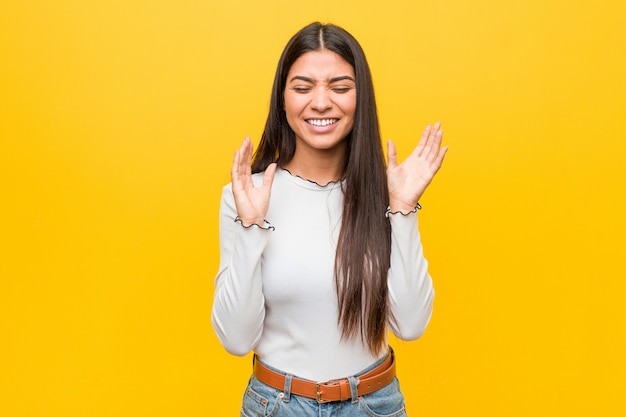 Young pretty arab woman against a yellow  joyful laughing a lot. Happiness .