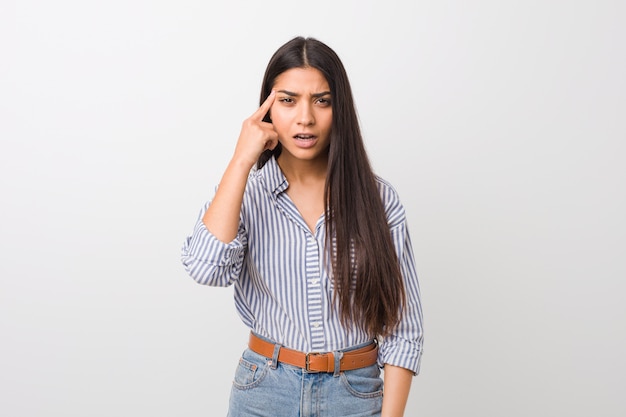 Young pretty arab woman showing a disappointment gesture with forefinger.