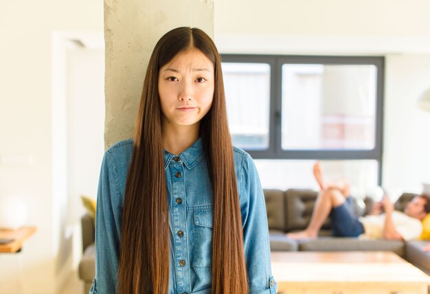 Young pretty asian woman feeling confused and doubtful, wondering or trying to choose or make a decision