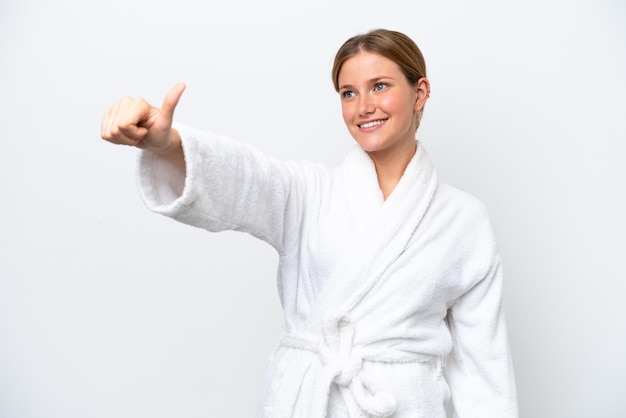 Young pretty blonde woman in bathrobe isolated on white background giving a thumbs up gesture