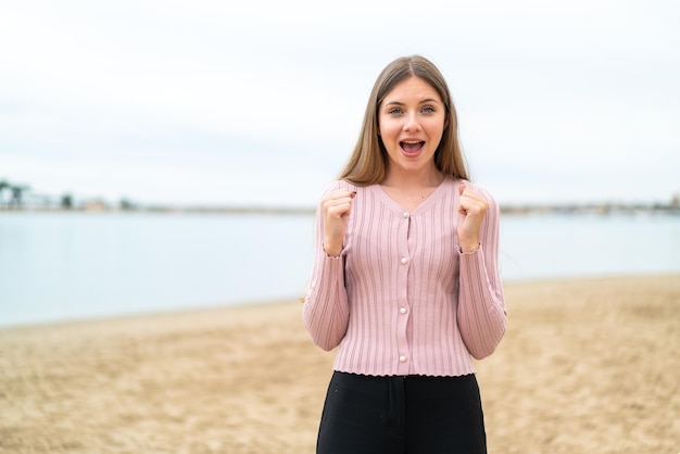 Young pretty blonde woman celebrating a victory in winner position