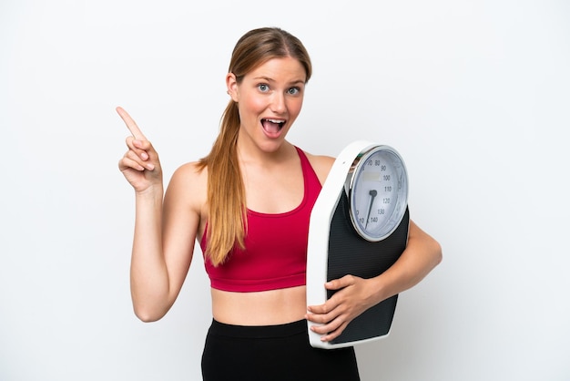 Young pretty blonde woman isolated on white background with weighing machine