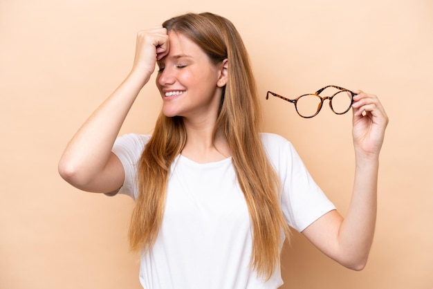 Young pretty blonde woman with glasses isolated on beige background has realized something and intending the solution