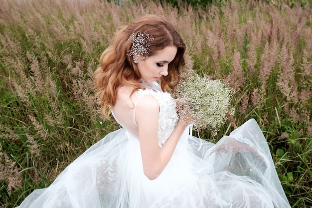 Young pretty bride in white wedding dress outdoors