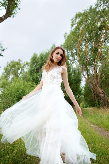 Young pretty bride in white wedding dress spin around