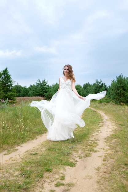 Young pretty bride in white wedding dress spin around