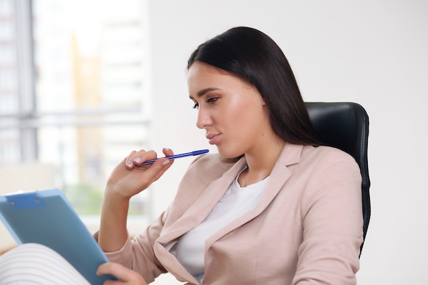 Young pretty business woman with notebook in the office