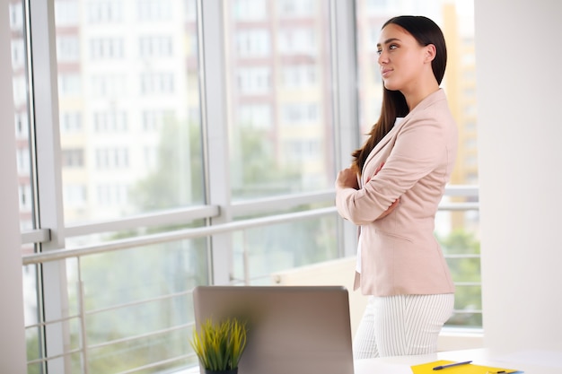 Young pretty business woman with notebook in the office.