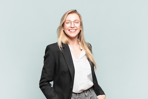 Photo young pretty businesswoman smiling cheerfully and casually with a positive, happy, confident and relaxed expression