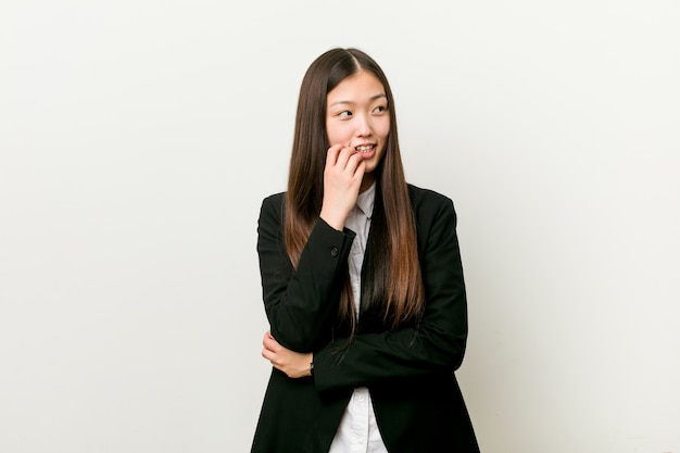 Young pretty chinese business woman relaxed thinking about something looking at a copy space.