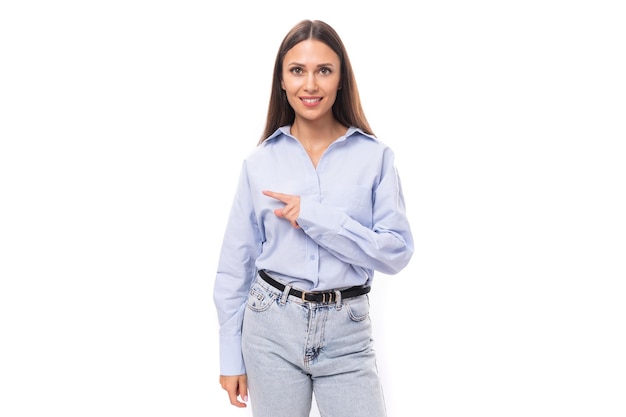 Young pretty european business lady with long black hair dressed in a blue blouse points her hand to