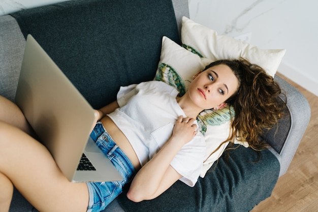 young pretty female online shopping on laptop with credit card in hand