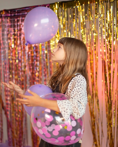 Young pretty girl at festive party with balloons