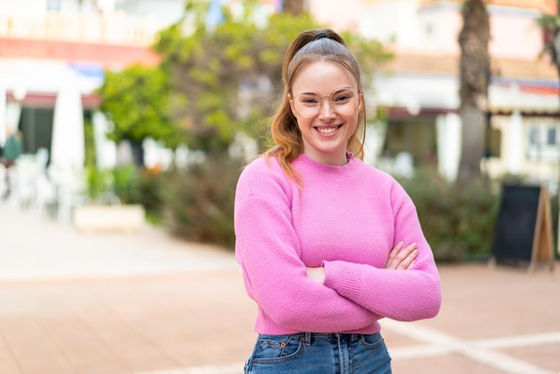 Young pretty girl at outdoors With glasses with happy expression