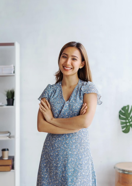 Young pretty hands crossed asian business woman when standing at desk in modern office