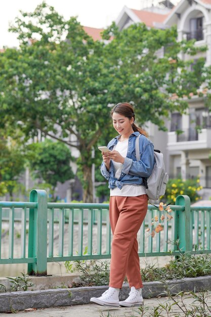 Young pretty hipster cheerful girl posing on the street at sunny day