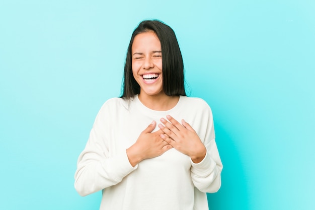 Young pretty hispanic woman laughing keeping hands on heart, concept of happiness.